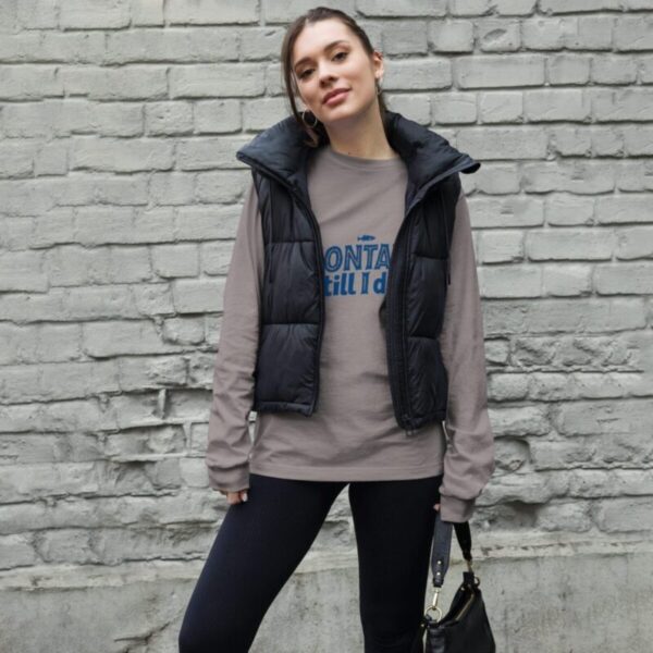 Woman wearing a stylish Montauk sweatshirt, standing near the beach on a breezy day.